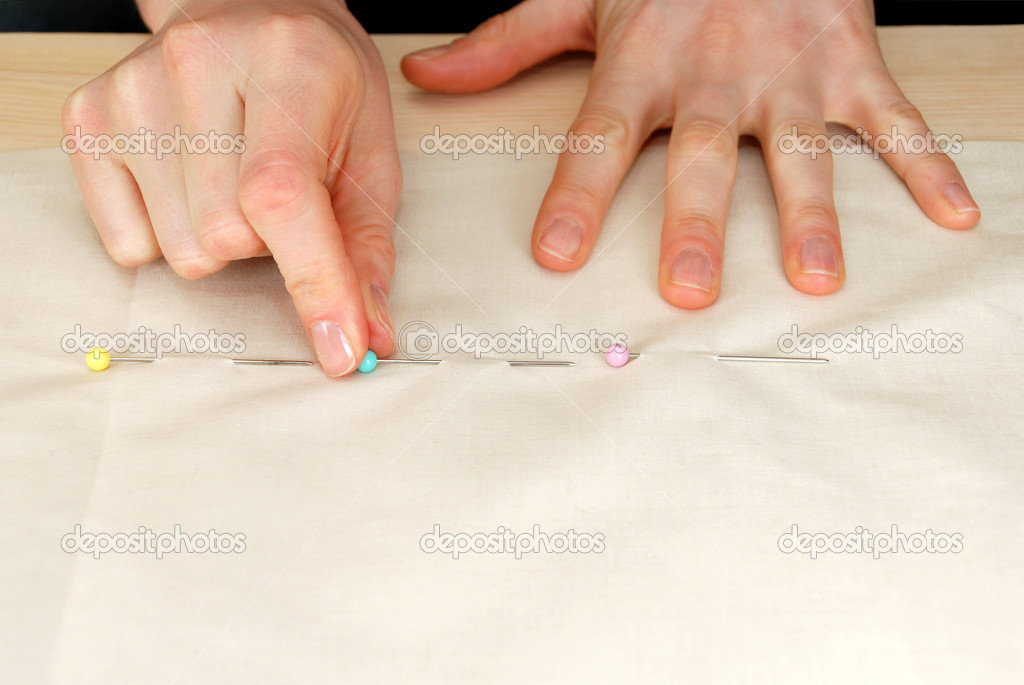 Closeup of large upholstery pins being pinned into plain fabric Stock Photo  by ©sarahdoow 23704471